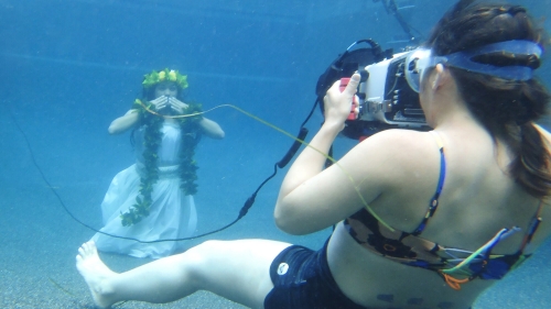 hawaiian woman being photographed while underwater