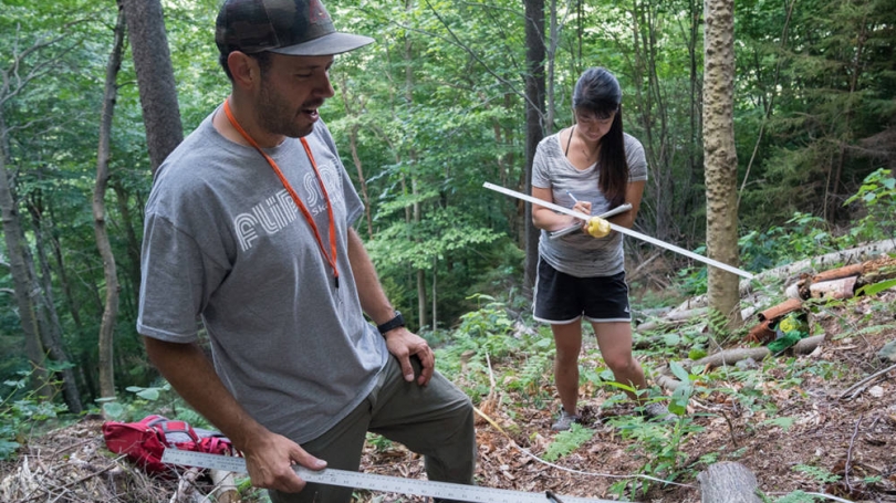 Reo and a student examine vegetation at Green Mountain in Rochester, Vt.