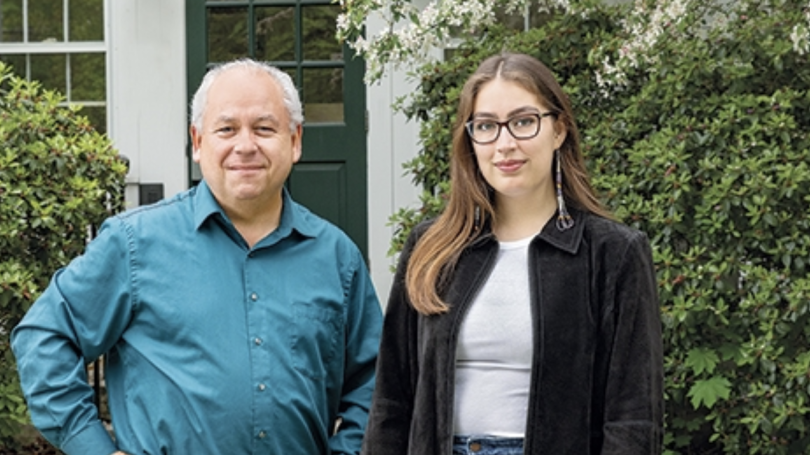 Older man and young woman in front of white house